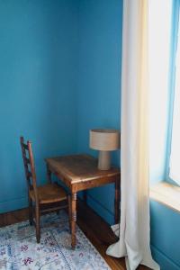 a table and a chair in a room with a blue wall at Appartement Nr 1 Centre Ville 2 personnes 50m2 rénové in Tarbes
