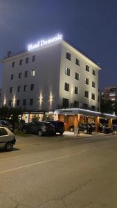 a building with cars parked in a parking lot at Hotel Domenic FREE PARKING in Plovdiv