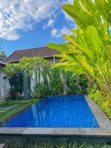 a pool in front of a house with a garden at Good Karma House Ubud in Ubud
