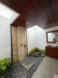 a bathroom with a sink and a shower with a plant at Good Karma House Ubud in Ubud