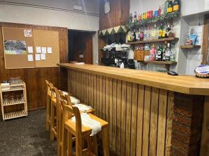 a bar in a restaurant with a row of chairs at Refugi La Basseta in Vall de Castellbò