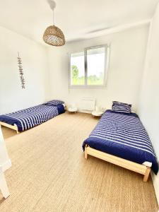 a bedroom with two beds and a window at Proche plage de Royan, vue mer, équipements modernes, confort in Saint-Georges-de-Didonne