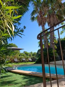 uitzicht op een zwembad met palmbomen bij Villa Carry Piscine Sauna Jacuzzi in Carry-le-Rouet