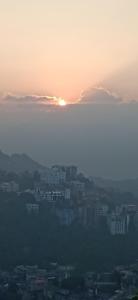 een skyline van de stad met zonsondergang in de lucht bij W-26 Dawrpui in Aizawl +3 foto's