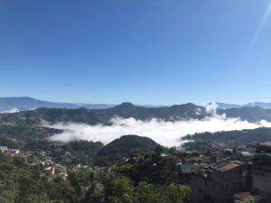 a view of a city with clouds in the mountains at W-26 Dawrpui in Āīzawl +16 photos