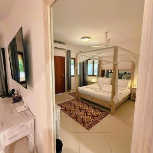 a bedroom with a canopy bed in a room at Jumeirah Malindi Hotel in Malindi