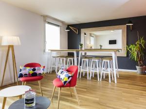 a living room with red chairs and a table at Aparthotel Adagio Access Strasbourg Illkirch in Illkirch-Graffenstaden