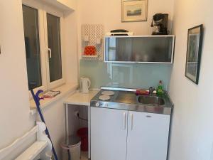 a small kitchen with a sink and a microwave at Apartment Sanja in Primošten