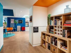 a library with wooden bookshelves and a desk at Aparthotel Adagio Access Marseille Prado Périer in Marseille