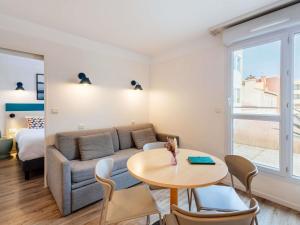 a living room with a couch and a table at Aparthotel Adagio Access Marseille Prado Périer in Marseille