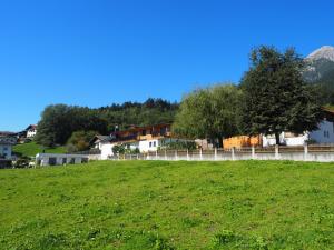 un campo verde con casas y una valla en Plattnerhof, en Thaur
