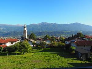 una pequeña ciudad con una iglesia y montañas en el fondo en Plattnerhof, en Thaur