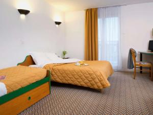 a hotel room with two beds and a window at Aparthotel Adagio Access Paris Maisons-Alfort in Maisons-Alfort