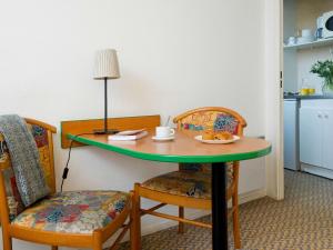 a table with a plate of food and two chairs at Aparthotel Adagio Access Paris Maisons-Alfort in Maisons-Alfort +21 photos