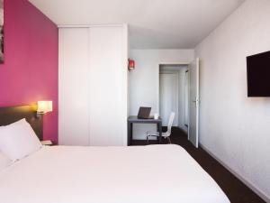 a bedroom with a white bed and a desk with a laptop at Aparthotel Adagio Access Strasbourg Petite France in Strasbourg +78 photos