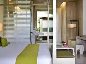 a bedroom with a green and white bed and a kitchen at Mercure Koh Chang Hideaway in Ko Chang +151 photos