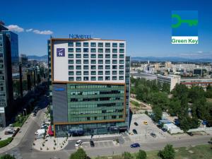 a large building with a sign on top of it at Novotel Sofia in Sofia