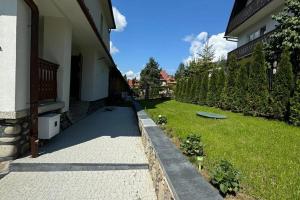a backyard of a house with a yard with a green lawn at Dom Muminków Kotelnica in Groń