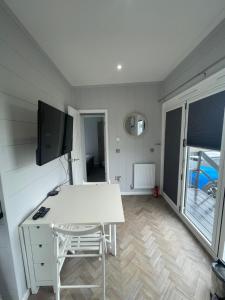 a room with a white desk and a tv at Sutton Fields Chalet in Preston on the Hill