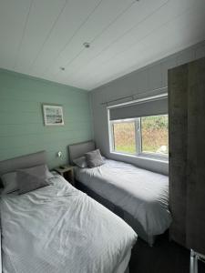 two beds in a room with a window at Sutton Fields Chalet in Preston on the Hill