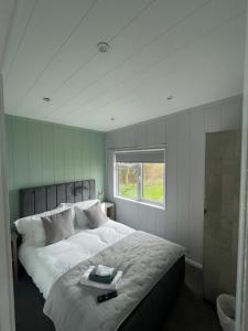 a bedroom with a large white bed with a window at Sutton Fields Chalet in Preston on the Hill