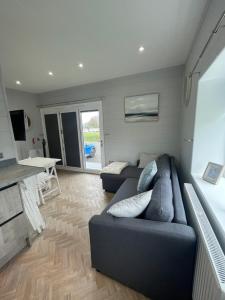 a living room with a couch and a table at Sutton Fields Chalet in Preston on the Hill