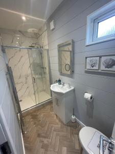 a bathroom with a shower and a sink at Sutton Fields Chalet in Preston on the Hill