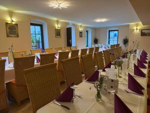a dining room with tables and chairs with purple napkins at Amara.Festsaal.Gasthaus.Pension in Mohorn
