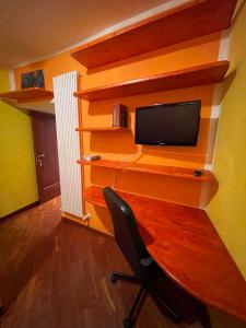 a room with a desk with a tv and a chair at La casa di Mene & Lù in Pesche