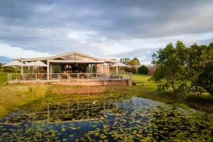 a house with a pond in front of it at Kay and Monty Vineyard View in The Crags