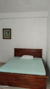a bed with a wooden frame in a room at River way in Ratnapura