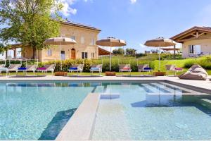 a swimming pool with chairs and umbrellas at Villa Margherita in Francavilla dʼEte