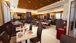 a dining room with tables and chairs in a restaurant at ASR Parklane, A Bergamont Hotel - Hosur in Hosūr