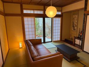 a living room with a leather couch and a table at Seiran静蘭 in Takayama