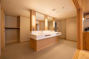 een badkamer met een wastafel en een grote spiegel bij soyo-ka kyoto sanjo in Kyoto +46 foto's