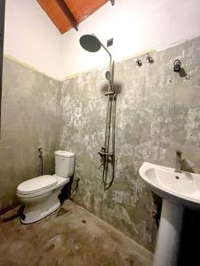 une salle de bains avec toilettes et lavabo dans l'établissement The Garden, à Ahangama