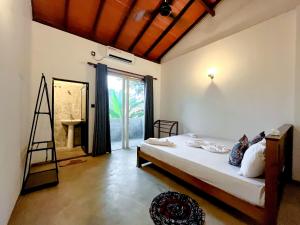 - une chambre avec un lit avec une échelle et une fenêtre dans l'établissement The Garden, à Ahangama