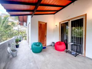 un patio avec deux fauteuils haricots rouges et bleus dans l'établissement The Garden, à Ahangama 14 autres photos