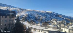 eine Gruppe von Gebäuden vor einem Berg in der Unterkunft SKI & SNOW APARTMENTS - PLAZA DE PRADOLLANO - Junto a los Telecabinas by TODOSIERRANEVADA in Sierra Nevada + 11 Fotos