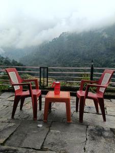 three chairs and a table with a view of a mountain at Global home stay in Sari +4 photos