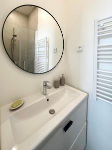 a bathroom with a white sink and a mirror at Le Langlais - 2P avec terrasse panoramique in La Celle-sous-Gouzon