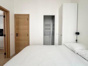 a bedroom with a white bed and a closet at Le Langlais - 2P avec terrasse panoramique in La Celle-sous-Gouzon