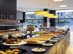 a buffet line with many different types of food at ibis BH Afonso Pena Savassi in Belo Horizonte