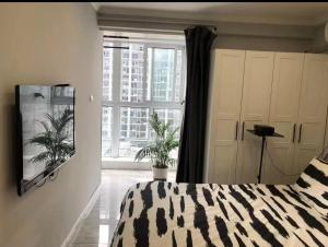 a bedroom with a bed and a large window at Aisen Apartment Huainan Wanda Plaza Near City Center in Huainan