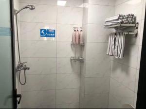 a shower in a bathroom with a sign on the wall at Aisen Apartment Huainan Wanda Plaza Near City Center in Huainan