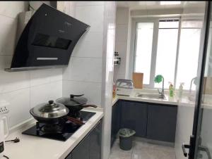 a kitchen with a stove with two pots on it at Aisen Apartment Huainan Wanda Plaza Near City Center in Huainan