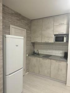 a kitchen with a white refrigerator and a microwave at Гагарина 119 in Dnipro