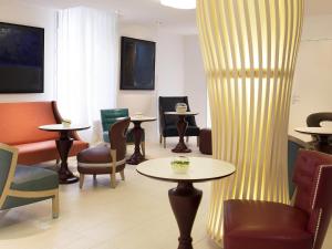 a waiting room with chairs and tables and a curtain at Mercure Paris Levallois in Levallois-Perret