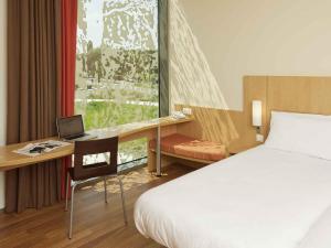 ein Hotelzimmer mit einem Bett und einem Schreibtisch mit einem Laptop in der Unterkunft ibis Heverlee Leuven in Löwen + 27 Fotos