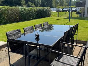 a ping pong table with chairs and a ping pong ball on it at Moderne Zimmer nähe A3 in Ransbach-Baumbach